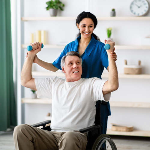 female physical therapist helping her senior patient with a rehabilitation exercise to improve strength after a stroke