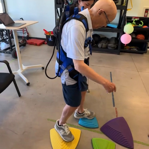 patient walks on foam cones on the floor during a vestibular therapy session at Advanced Neurologic Rehabilitation