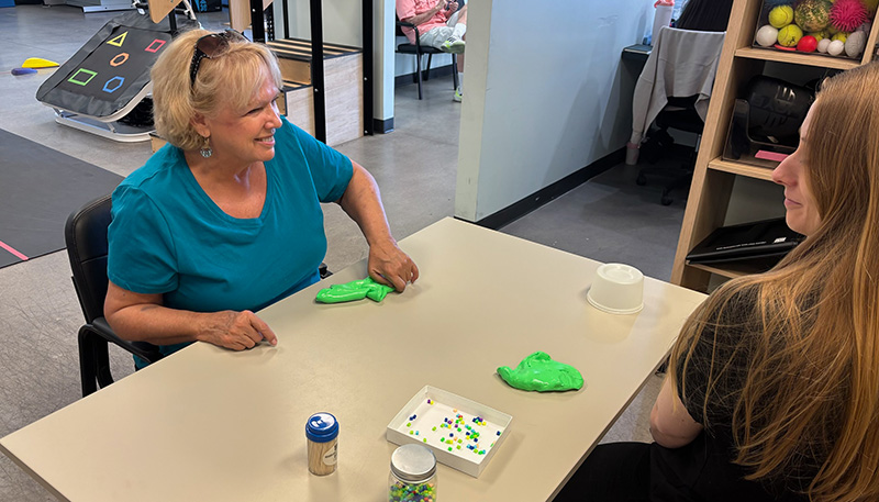patient and physical therapist doing a hand coordination exercise with putty