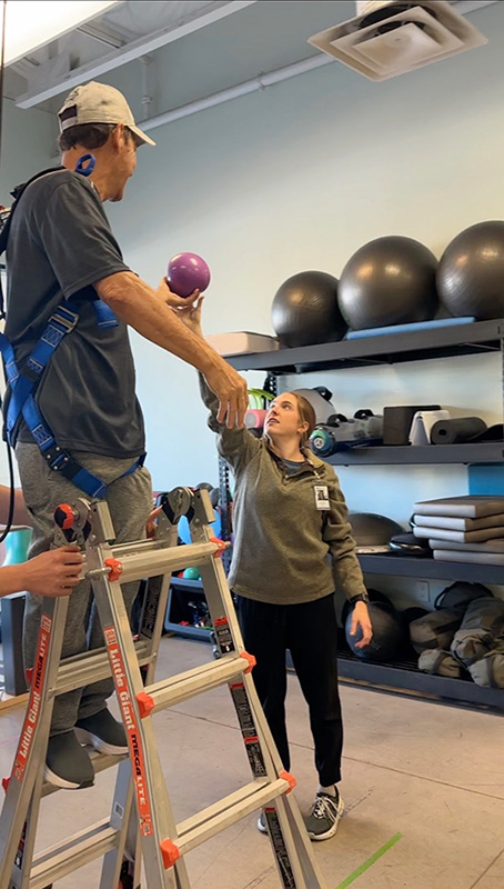 specialist guides a patient through a neurological rehab exercise to improve his coordination